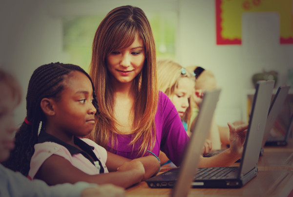 Woman with girl on computer in Netsmartz course on internet safety for parents and guardians